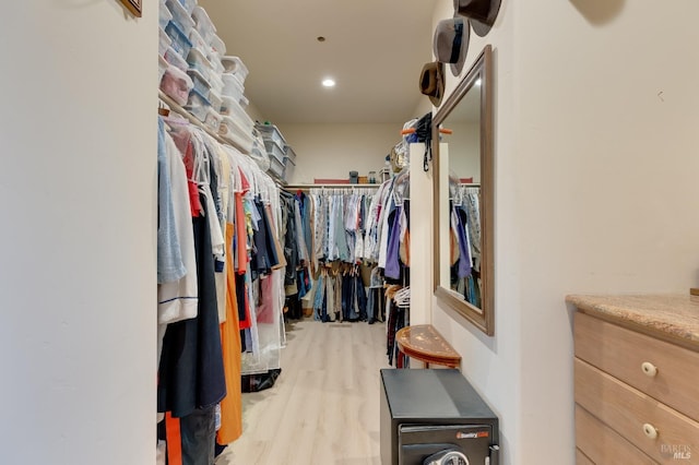 walk in closet with light hardwood / wood-style flooring