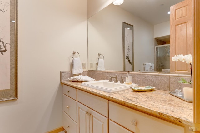 bathroom with backsplash, a stall shower, and vanity