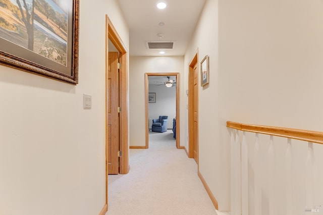 corridor featuring recessed lighting, visible vents, baseboards, and light colored carpet