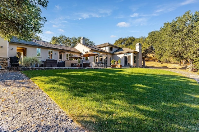 back of property featuring a patio area, stucco siding, and a lawn