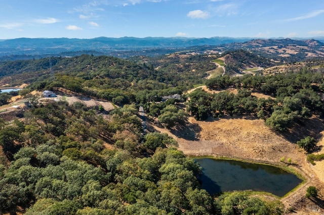 birds eye view of property with a wooded view and a water and mountain view
