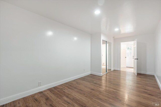 unfurnished room with wood-type flooring