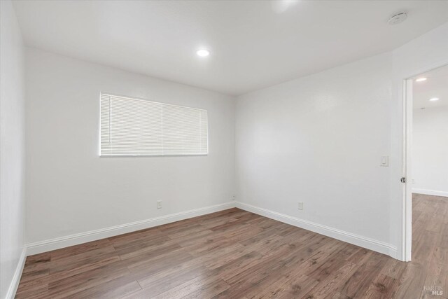 unfurnished room with wood-type flooring