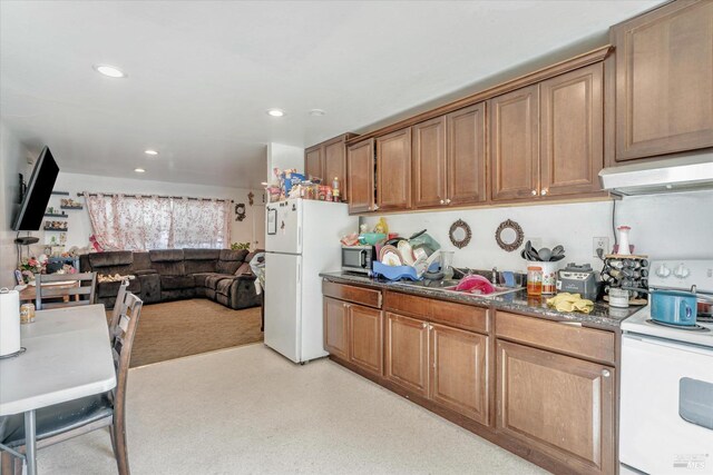 kitchen with white appliances and dark stone counters