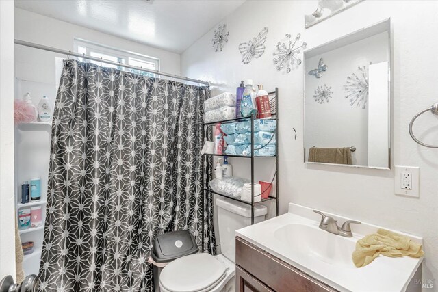 bathroom featuring vanity, toilet, and a shower with shower curtain