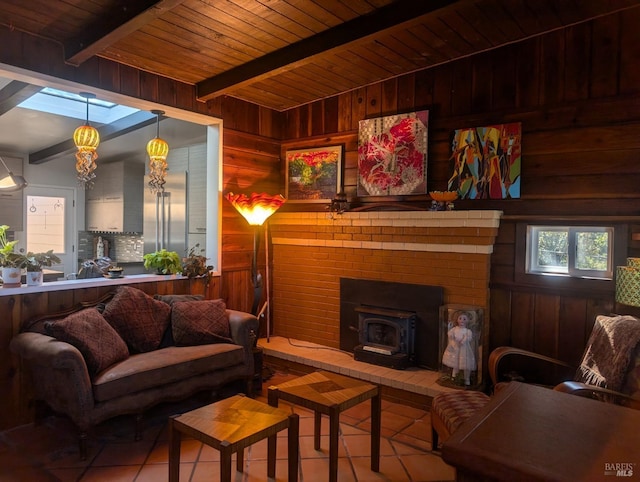 living room featuring beamed ceiling, wooden walls, wood ceiling, a wood stove, and light tile patterned floors