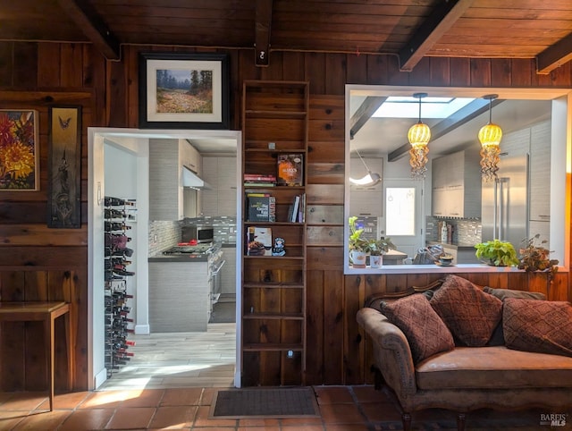 kitchen featuring pendant lighting, wooden walls, tile patterned flooring, and wood ceiling