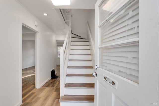 stairway featuring hardwood / wood-style floors and ornamental molding