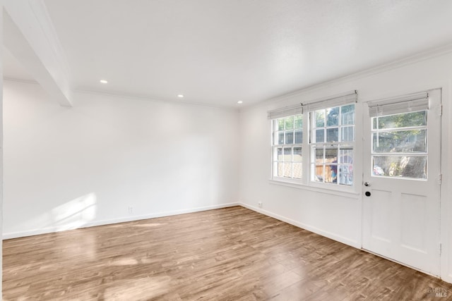 empty room with beamed ceiling, wood-type flooring, and ornamental molding