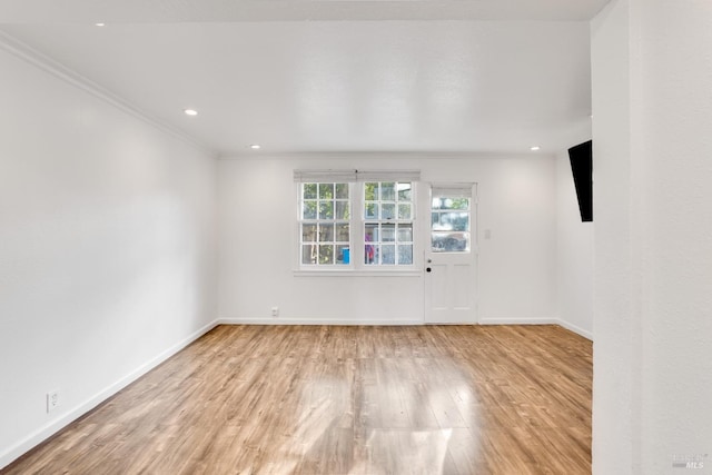 unfurnished room with light hardwood / wood-style floors and crown molding