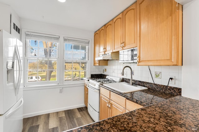 kitchen with dark hardwood / wood-style flooring, tasteful backsplash, white appliances, and sink