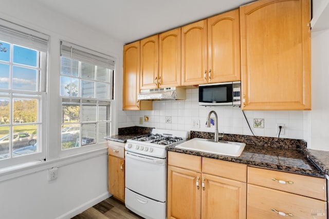 kitchen with light brown cabinetry, wood-type flooring, sink, and gas range gas stove