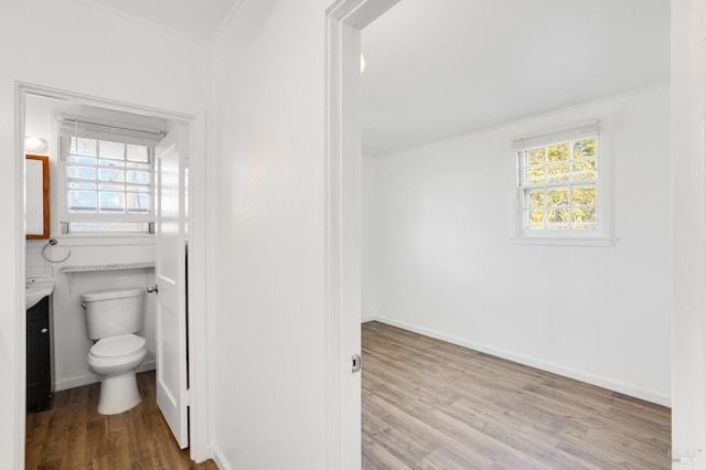 bathroom with wood-type flooring, vanity, toilet, and ornamental molding