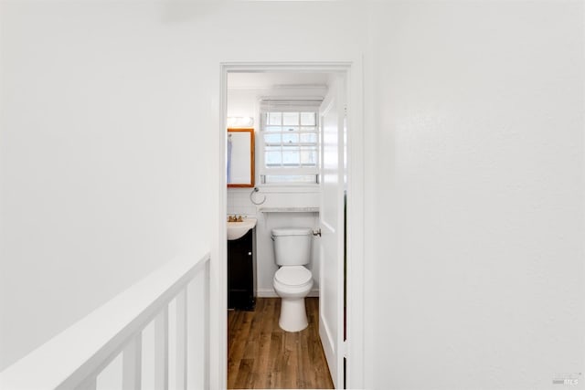 bathroom with toilet, vanity, and hardwood / wood-style flooring