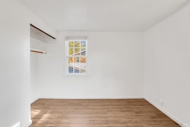 unfurnished room featuring wood-type flooring and ornamental molding