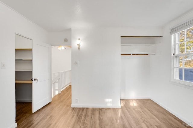 empty room featuring light wood-type flooring and ornamental molding