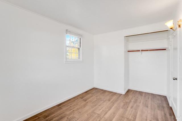 unfurnished bedroom with light hardwood / wood-style flooring and a closet