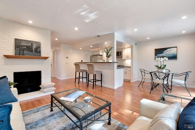 living room featuring a fireplace and light hardwood / wood-style flooring