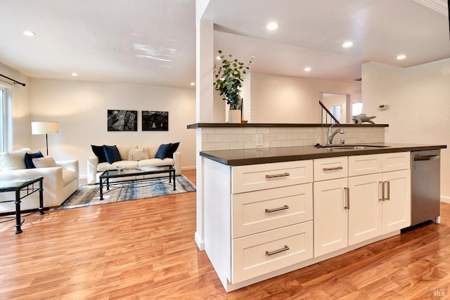 kitchen with white cabinets, sink, tasteful backsplash, dishwasher, and light hardwood / wood-style floors