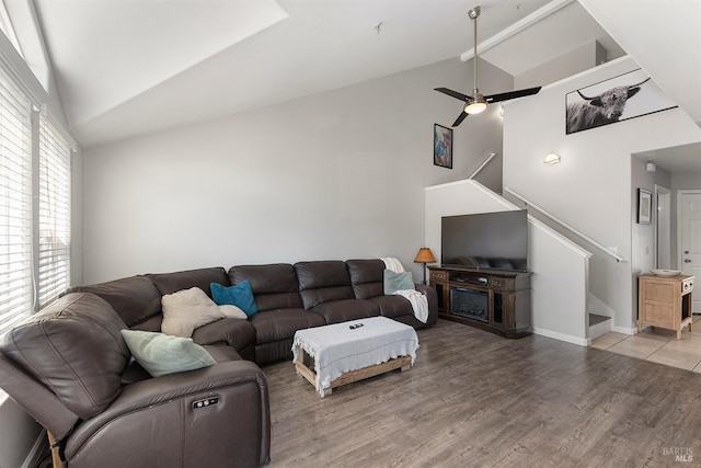 living room featuring ceiling fan, wood-type flooring, and vaulted ceiling