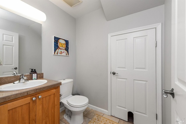 bathroom with toilet, vanity, and tile patterned floors