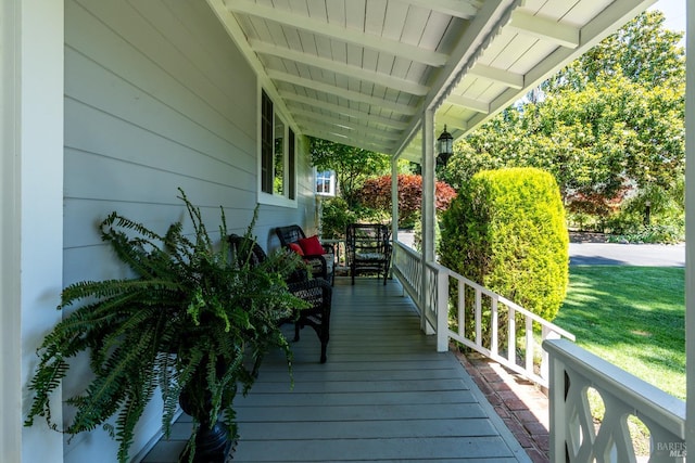 wooden terrace with a yard and covered porch