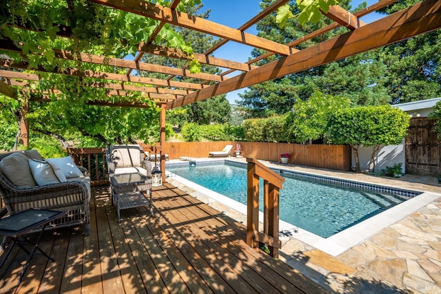 view of swimming pool with a wooden deck and a pergola