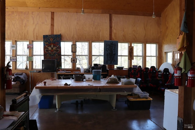 dining area with a high ceiling and wooden walls