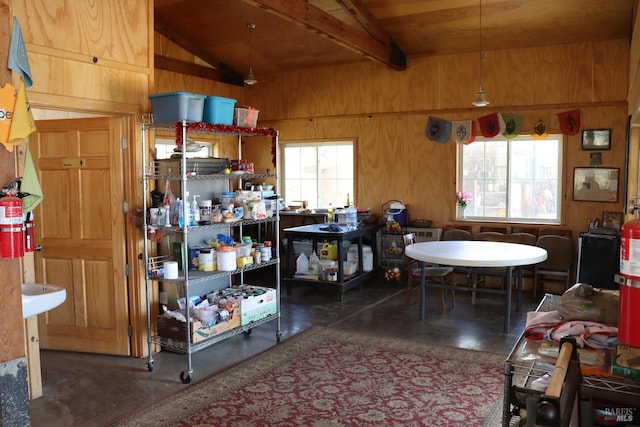 kitchen with a wealth of natural light, wooden walls, wooden ceiling, and vaulted ceiling with beams