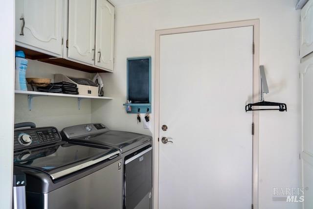 clothes washing area featuring cabinets and independent washer and dryer