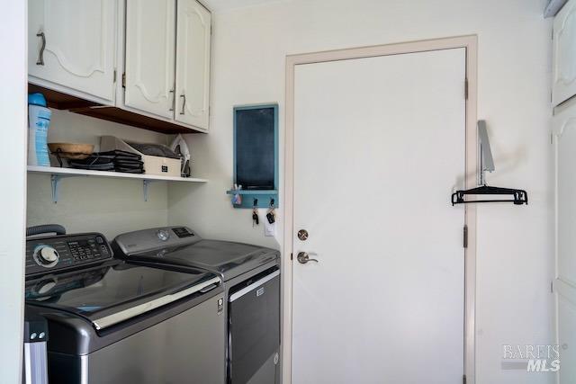 washroom with cabinet space and washer and clothes dryer