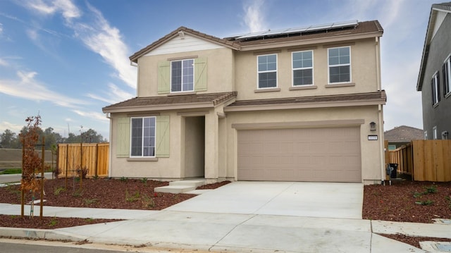 view of front of property with a garage and solar panels