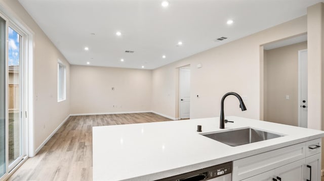 kitchen featuring white cabinetry, sink, light hardwood / wood-style floors, and a healthy amount of sunlight