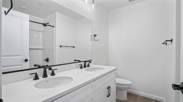 bathroom featuring walk in shower, vanity, toilet, and hardwood / wood-style flooring