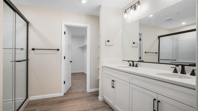 bathroom with vanity, an enclosed shower, and wood-type flooring