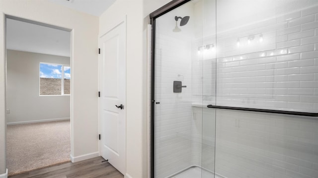 bathroom with hardwood / wood-style flooring and an enclosed shower