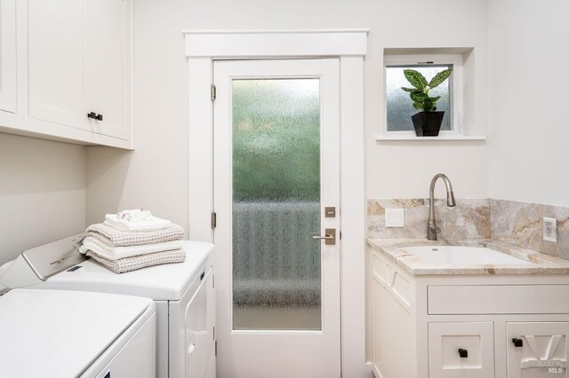 laundry area with washer and clothes dryer, cabinets, and sink