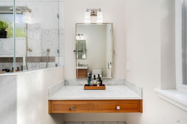 bathroom featuring a shower with shower door, vanity, and toilet