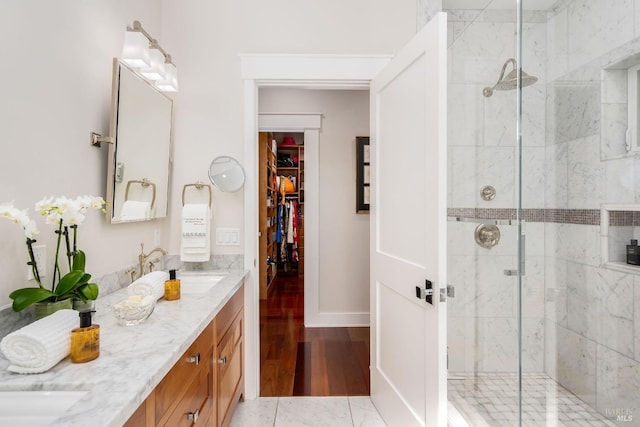 bathroom featuring a shower with door, vanity, and wood-type flooring