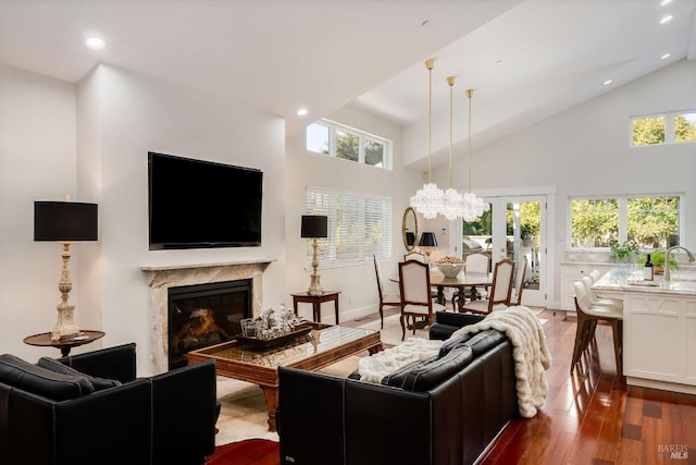 living room featuring a premium fireplace, dark hardwood / wood-style flooring, and high vaulted ceiling