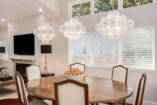 dining area featuring hardwood / wood-style flooring, a fireplace, and a chandelier