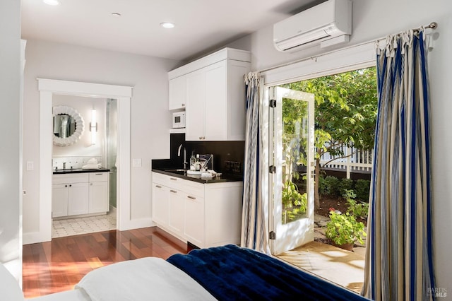 interior space featuring white cabinets, sink, a wall mounted air conditioner, and dark hardwood / wood-style flooring