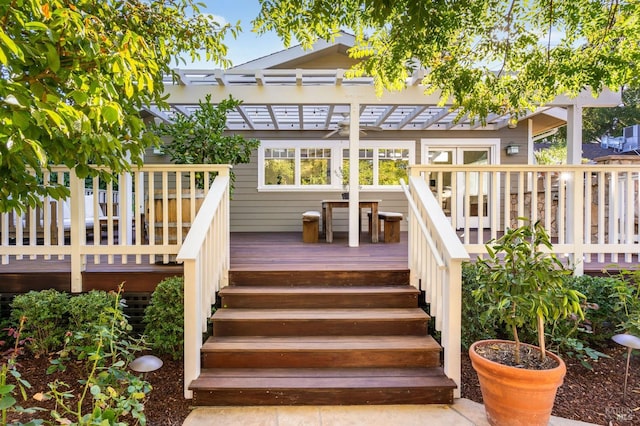 rear view of house with a wooden deck and a pergola