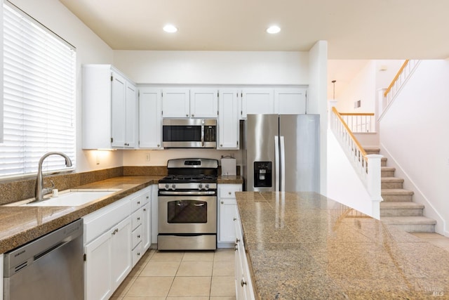 kitchen featuring light tile patterned flooring, sink, appliances with stainless steel finishes, a wealth of natural light, and white cabinets