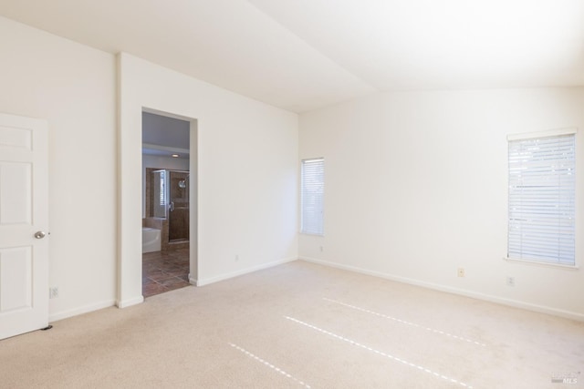 carpeted spare room with lofted ceiling