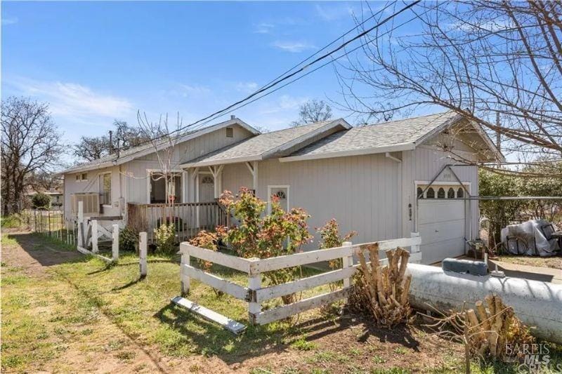 view of side of property with a garage and a lawn