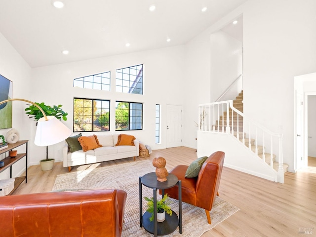 living room featuring light hardwood / wood-style flooring and high vaulted ceiling