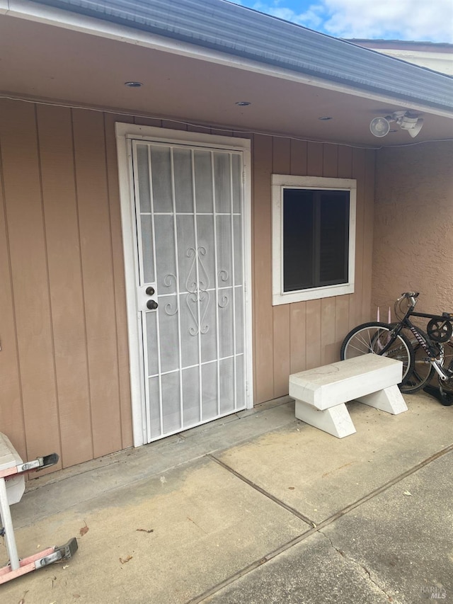 view of exterior entry with a patio area