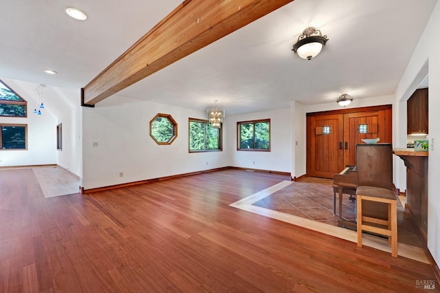 foyer entrance with an inviting chandelier, light wood-type flooring, and beam ceiling