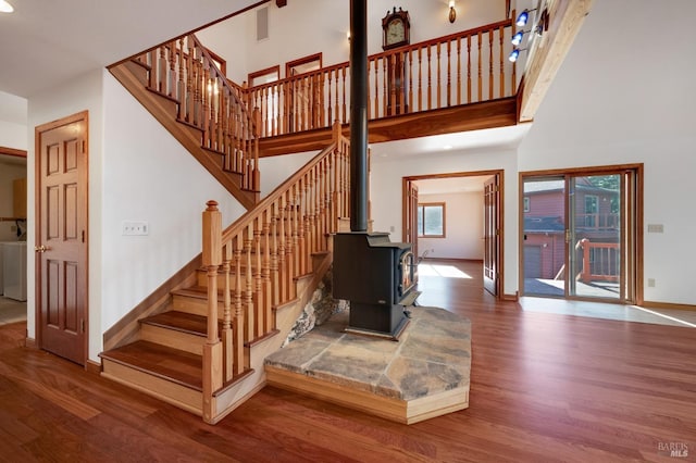 3925 Bay Hill Rd, Bodega Bay, CA 94923 - stairs featuring wood finished floors, a wood stove, a towering ceiling, and baseboards